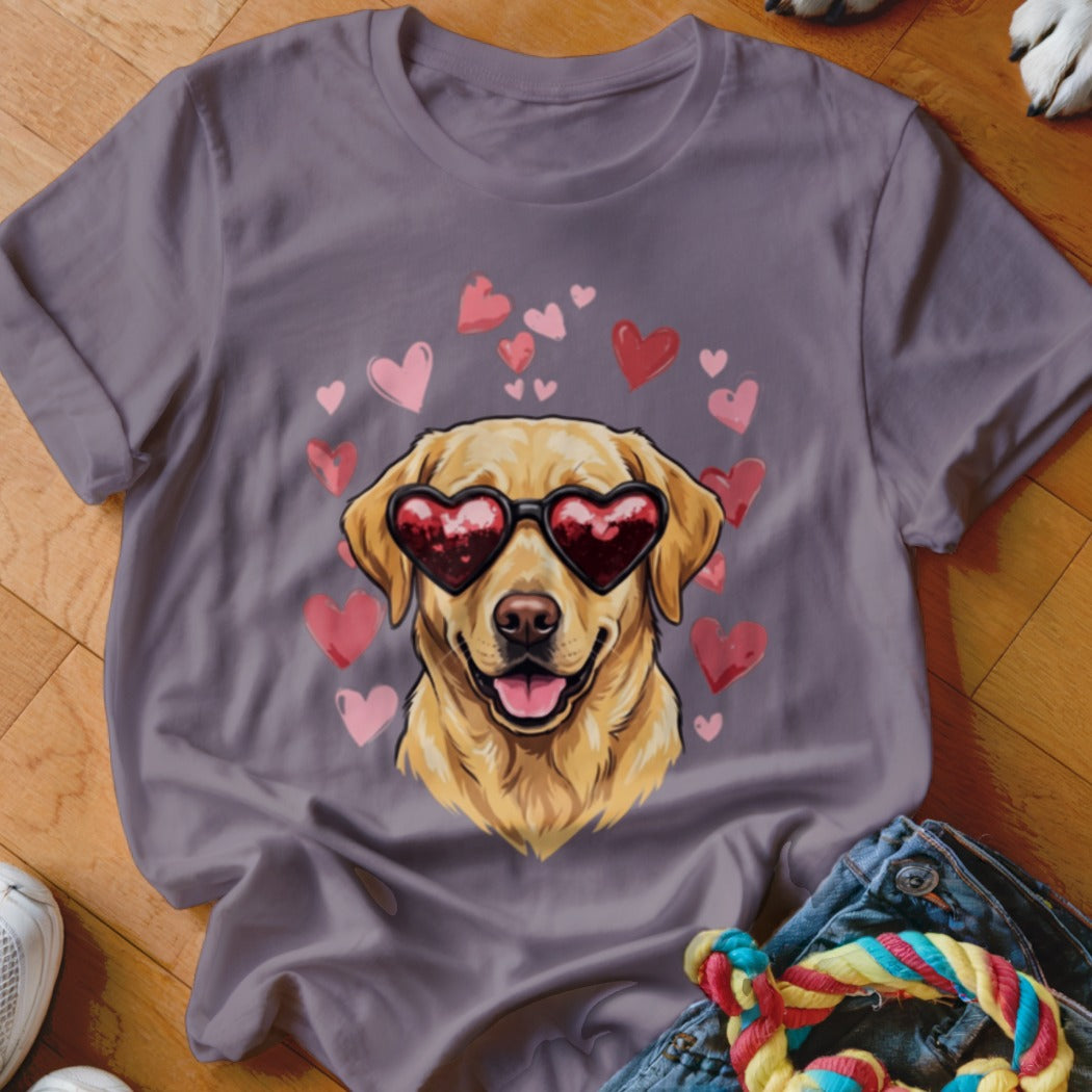 A purple t-shirt featuring a graphic of a golden retriever wearing heart-shaped sunglasses surrounded by pink hearts.