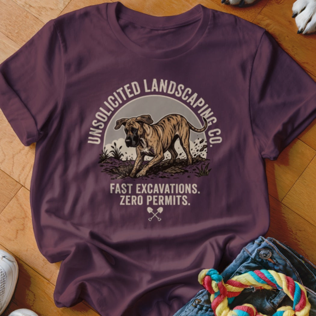 Maroon t-shirt with dog graphic and text: Unsolicited Landscaping Co. Fast Excavations. Zero Permits.