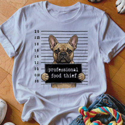 French bulldog mugshot with "professional food thief" sign on white t-shirt.