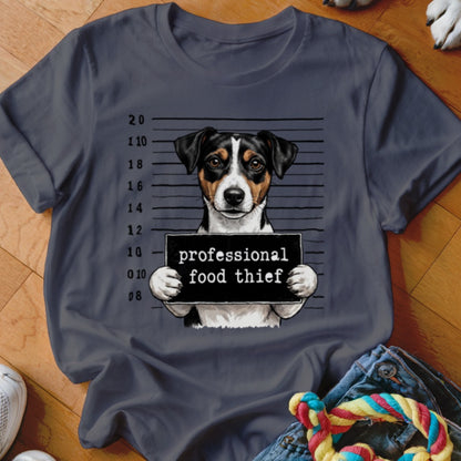 Jack Russell terrier in mugshot holding "professional food thief" sign.