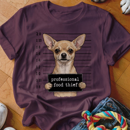 Chihuahua in mugshot holding a sign that says "professional food thief".