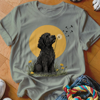 Sage green crewneck t-shirt featuring a graphic of a black dog blowing a dandelion.