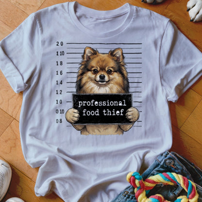 Pomeranian dog mugshot with "professional food thief" sign.