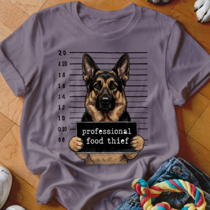 German Shepherd in mugshot holding "professional food thief" sign.