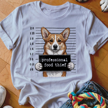 Corgi dog in mugshot holding "professional food thief" sign.