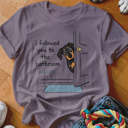 T-shirt graphic with dog peeking around door saying "i followed you to the bathroom. again."