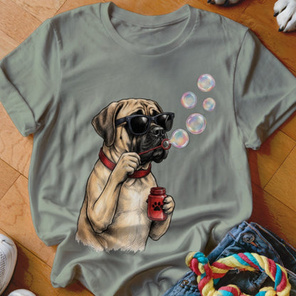 A sage green t-shirt featuring a graphic of a mastiff wearing sunglasses and blowing soap bubbles.