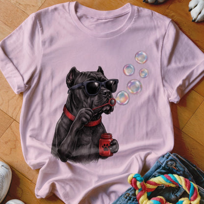 A light pink t-shirt featuring a graphic of a black dog wearing sunglasses and blowing soap bubbles.
