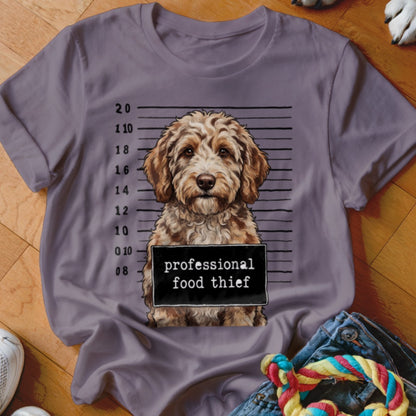 Brown dog in mugshot with "professional food thief" sign.