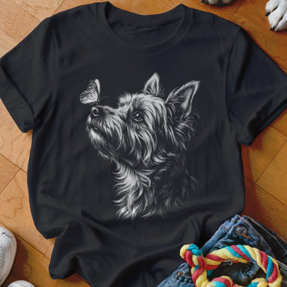 A black crewneck t-shirt featuring a white sketch graphic of a terrier looking at a butterfly on its nose.