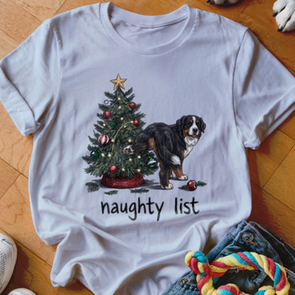 White t-shirt featuring a Bernese Mountain Dog lifting its leg on a Christmas tree with the text "naughty list".