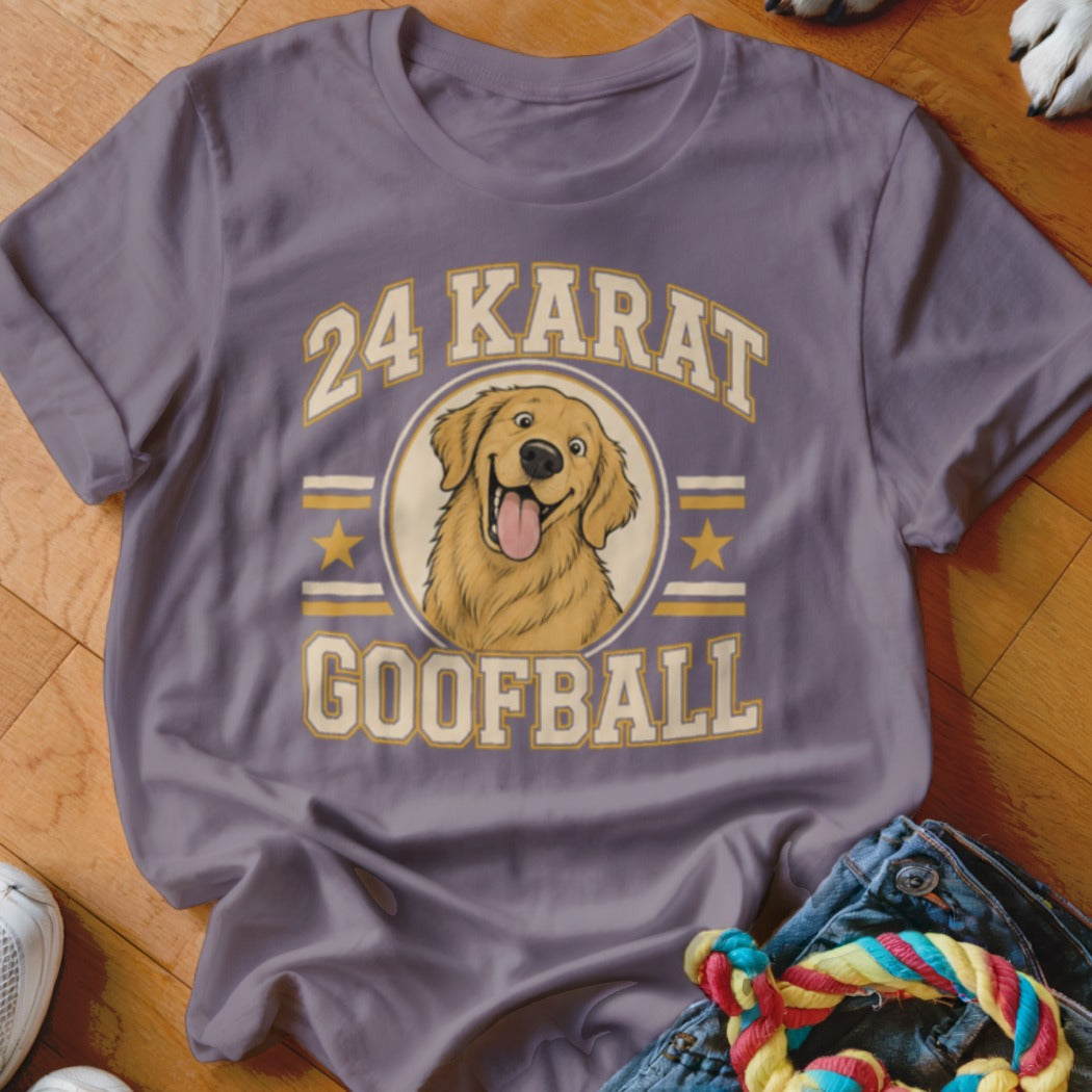 A dusty purple t-shirt featuring a cartoon golden retriever graphic with the text 24 Karat Goofball.