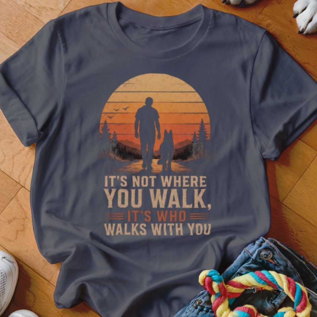 Dark grey t-shirt with sunset graphic of person and dog. Text says "It's not where you walk, it's who walks with you."