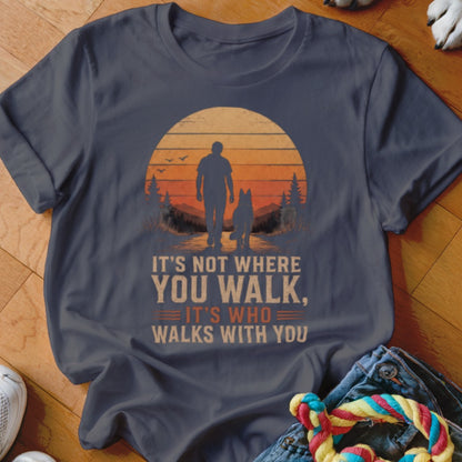 Dark grey t-shirt with sunset graphic of person and dog. Text says "It's not where you walk, it's who walks with you."
