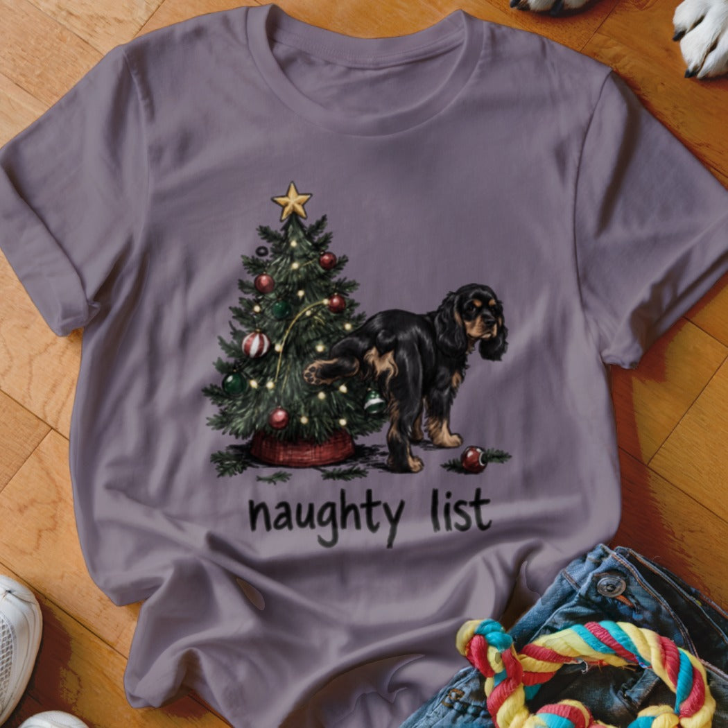 T-shirt with drawing of dog near Christmas tree and text "naughty list".