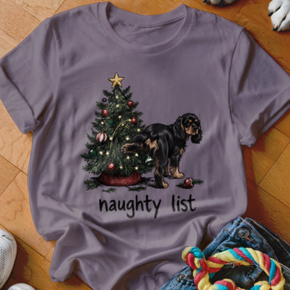 T-shirt with drawing of dog near Christmas tree and text "naughty list".