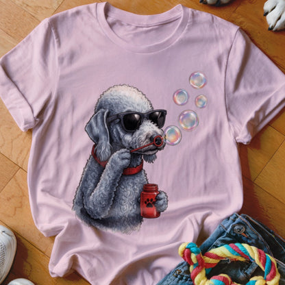 A pink t-shirt features a graphic of a grey poodle wearing sunglasses and blowing bubbles.