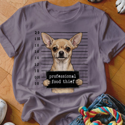 Chihuahua in mugshot holding a sign that reads "professional food thief".