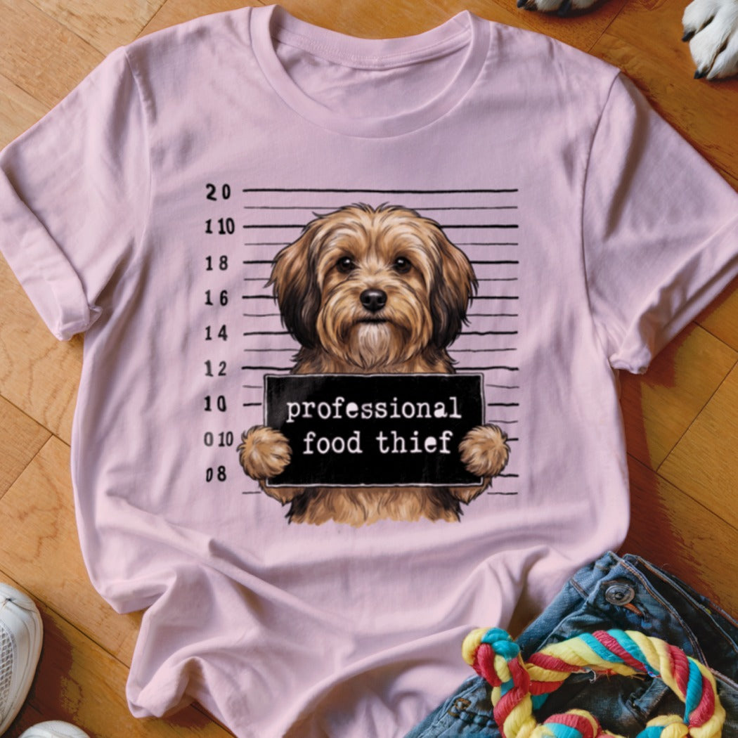 Light pink t-shirt with a dog mugshot graphic reading "professional food thief".