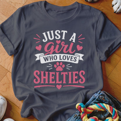 Dark grey t-shirt with pink text that says "JUST A girl WHO LOVES SHELTIES".