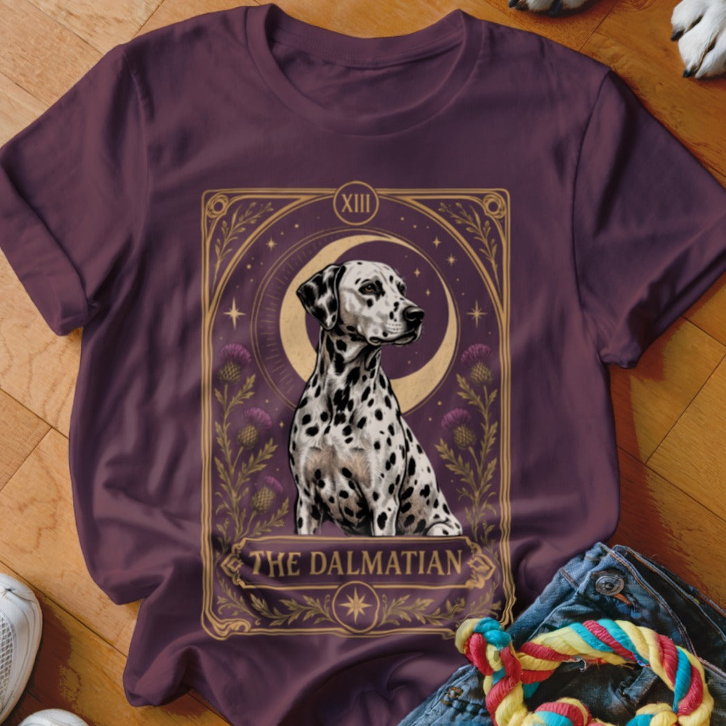 A dark purple t-shirt features a tarot-style graphic of a Dalmatian surrounded by thistles and a crescent moon.