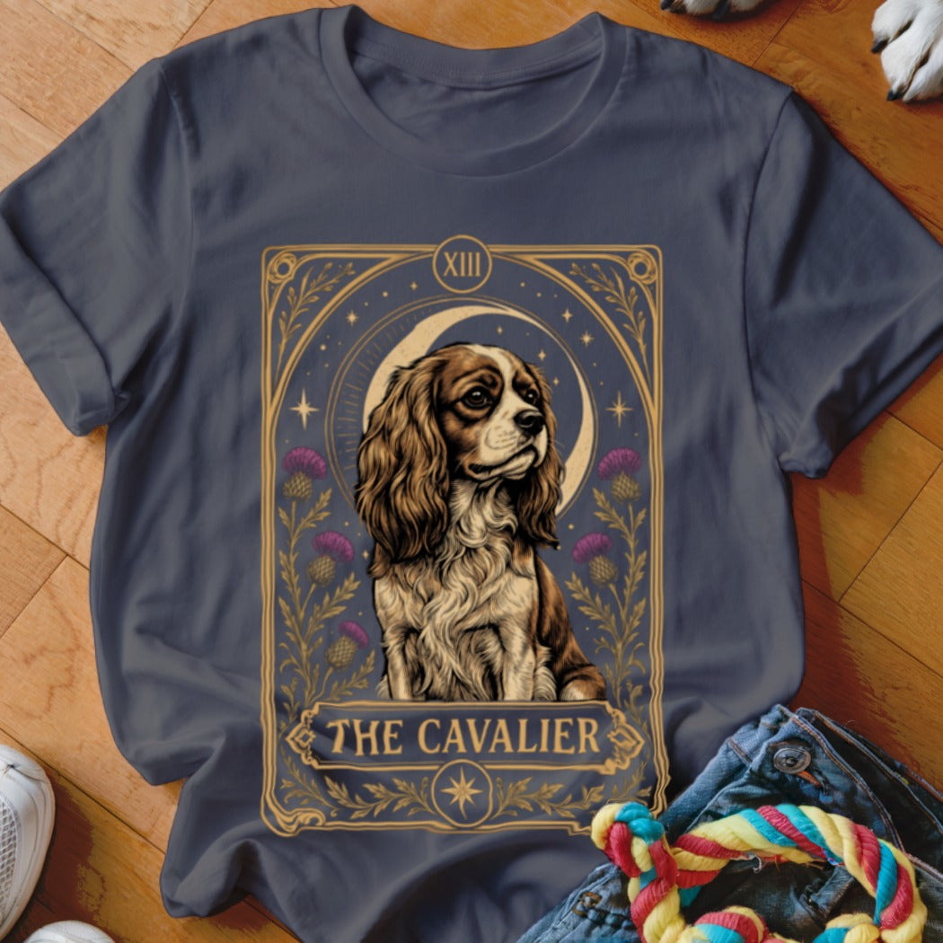 A dark grey crewneck t-shirt featuring a tarot card graphic of a Cavalier King Charles Spaniel with the text "THE CAVALIER".