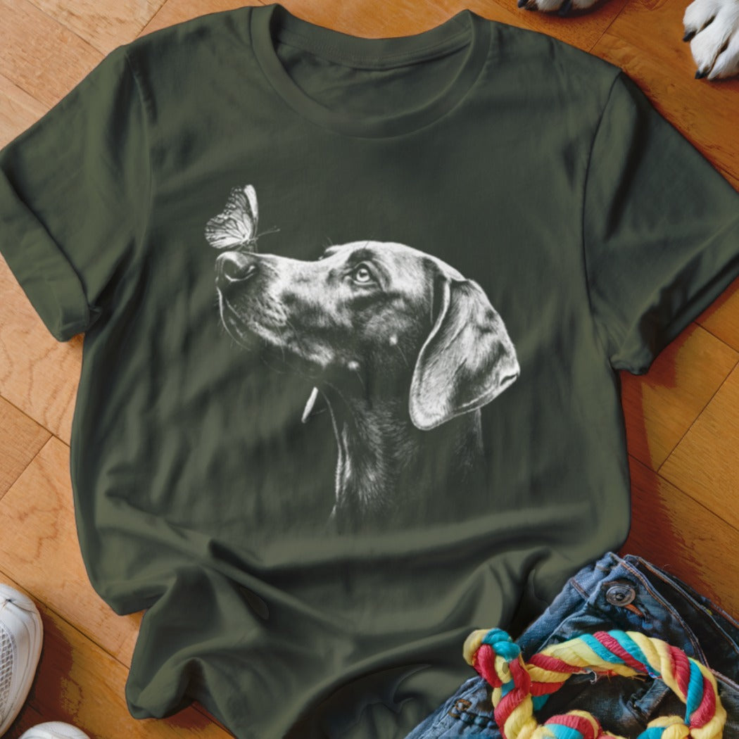 Dark green crewneck t-shirt featuring a white graphic of a dog looking at a butterfly on its nose.