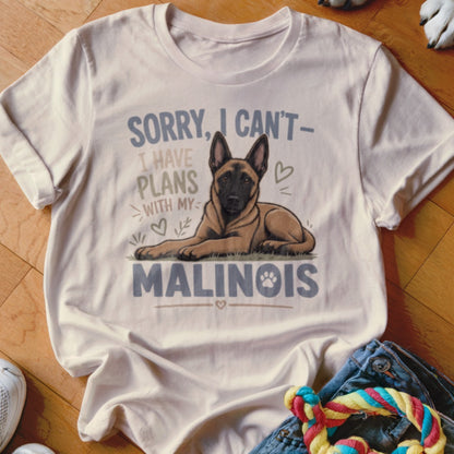 White t-shirt with a Malinois dog graphic and text "Sorry, I can't have plans with my Malinois."