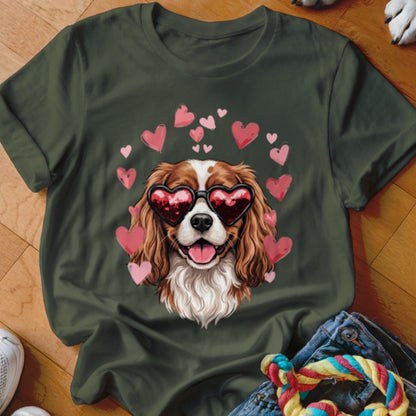 Dark green t-shirt featuring a graphic of a Cavalier King Charles Spaniel wearing heart-shaped sunglasses surrounded by pink hearts.