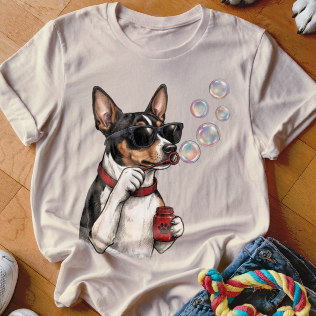 A light-colored t-shirt featuring a graphic of a dog in sunglasses blowing bubbles.