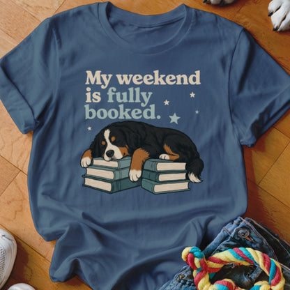 Bernese Mountain Dog sleeping on books with "My weekend is fully booked" text.