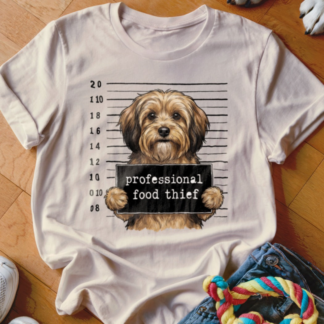 T-shirt graphic of a dog in a mugshot with text "professional food thief".