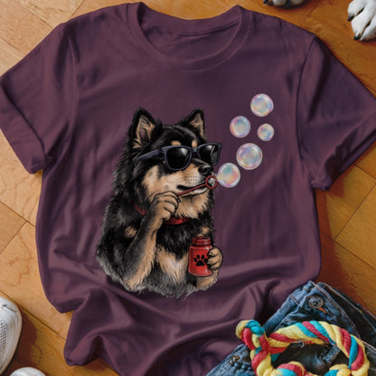 A maroon t-shirt featuring an illustration of a black and tan dog wearing sunglasses and blowing bubbles.