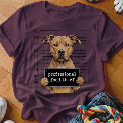 Pit bull dog mugshot sign reads "professional food thief" on plum t-shirt.