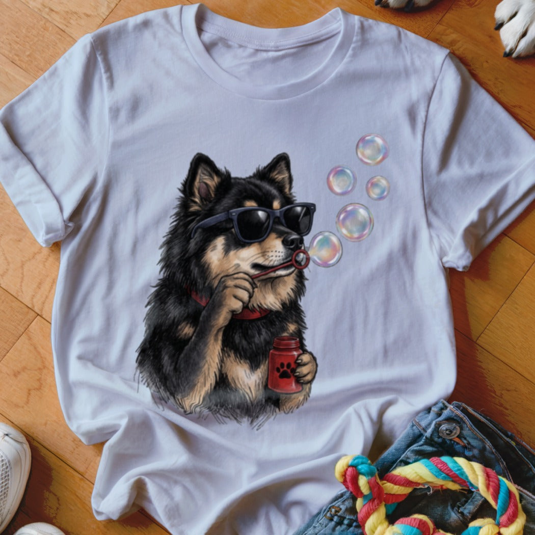 A white t-shirt featuring an illustration of a black and tan dog wearing sunglasses and blowing bubbles.