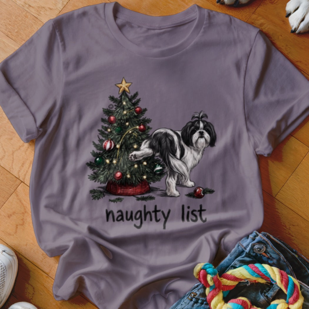 A grey t-shirt featuring a graphic of a Shih Tzu dog peeing on a decorated Christmas tree, with the text "naughty list" below.