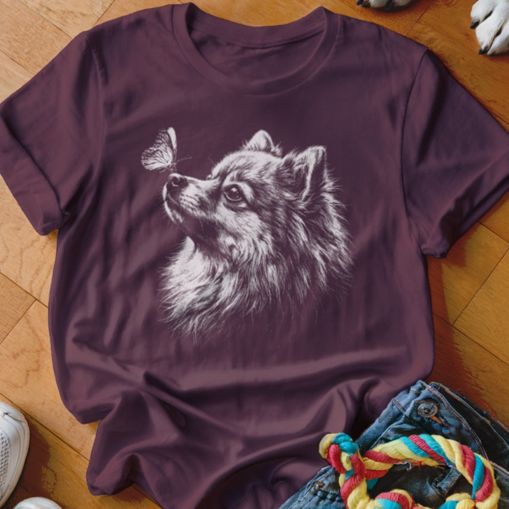 Maroon t-shirt featuring a white line drawing of a fluffy dog and a butterfly.