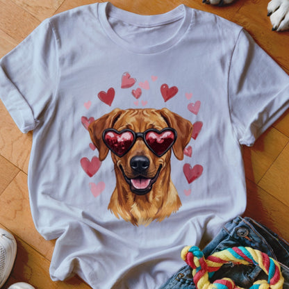 A white t-shirt featuring a graphic of a golden dog wearing heart-shaped sunglasses surrounded by pink and red hearts.