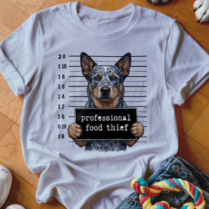Australian Cattle Dog mugshot with "professional food thief" sign on a white t-shirt.