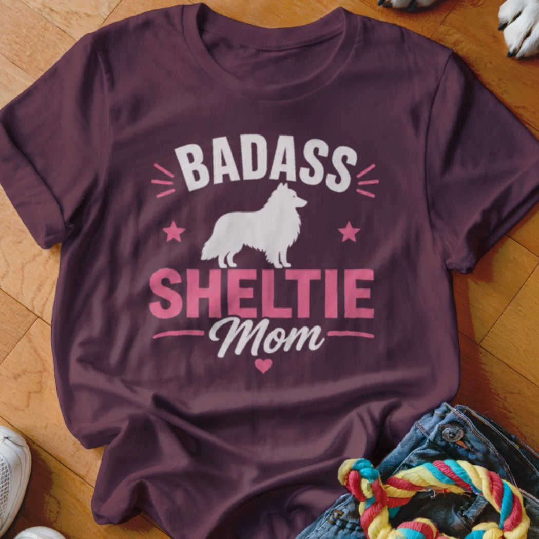 Burgundy t-shirt with white silhouette of a Sheltie and "Badass Sheltie Mom" text.