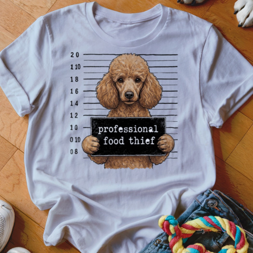 Brown poodle in a mugshot with "professional food thief" sign.