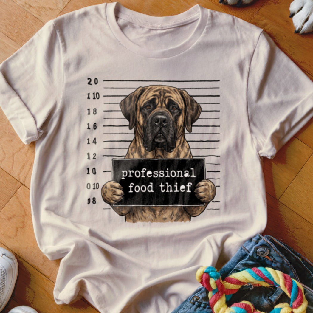 Dog mugshot with text "professional food thief" on a t-shirt.