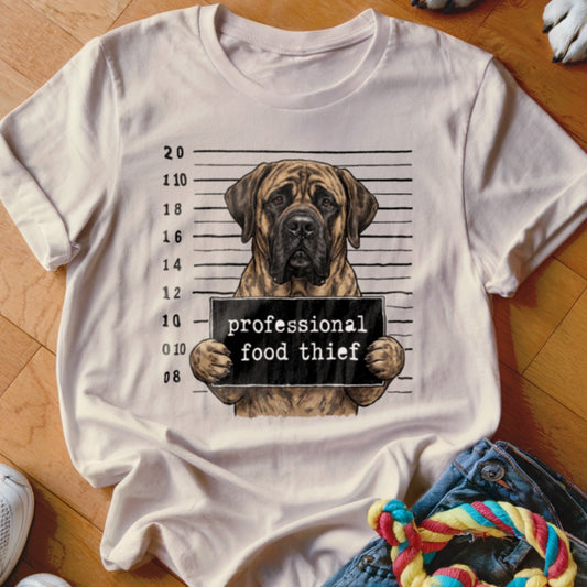 Dog mugshot with text "professional food thief" on a t-shirt.
