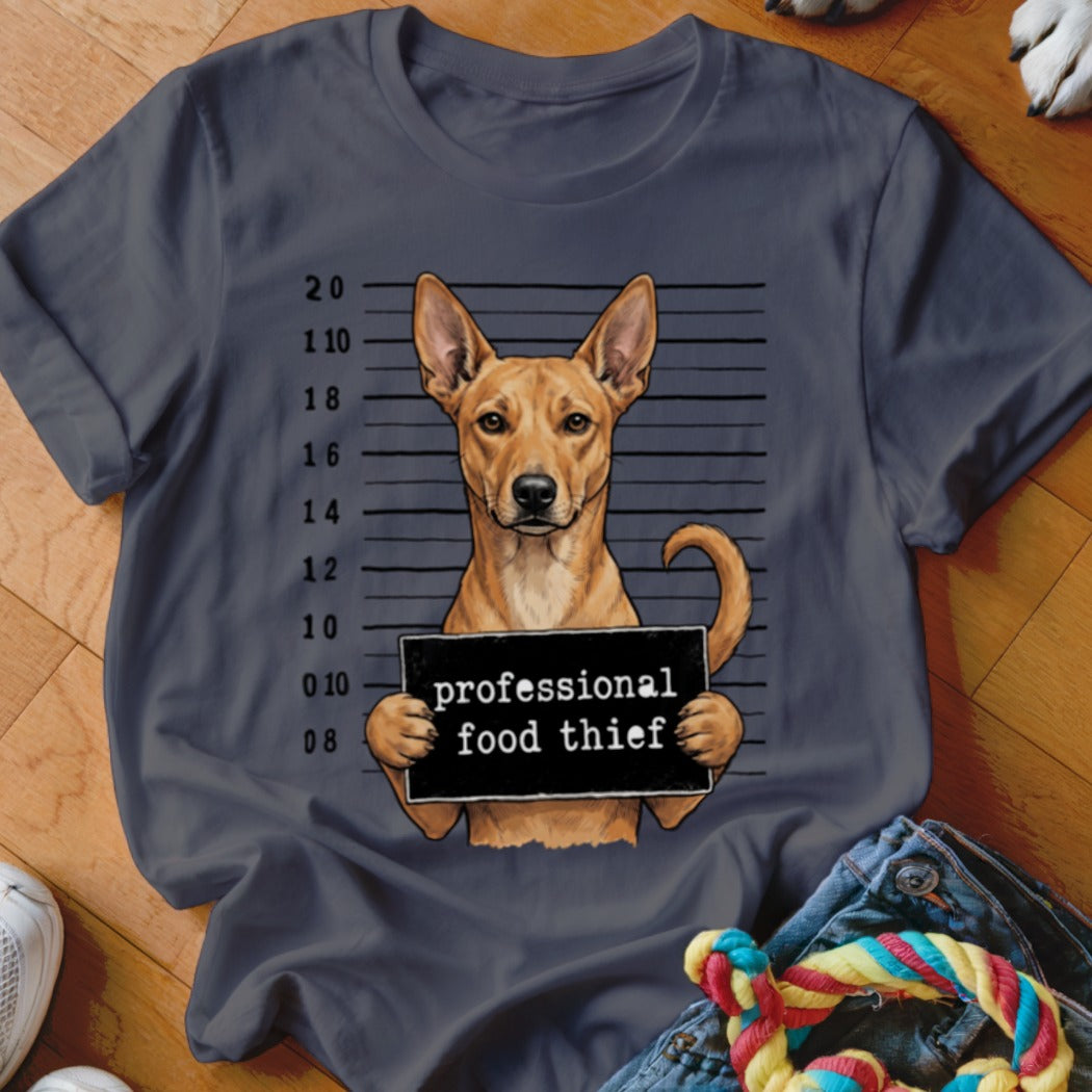 Dog mugshot with "professional food thief" sign on a dark gray t-shirt.