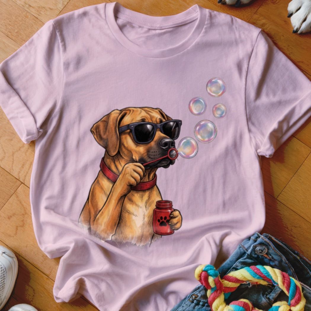 Light pink t-shirt featuring a graphic of a brown dog wearing sunglasses and blowing soap bubbles.