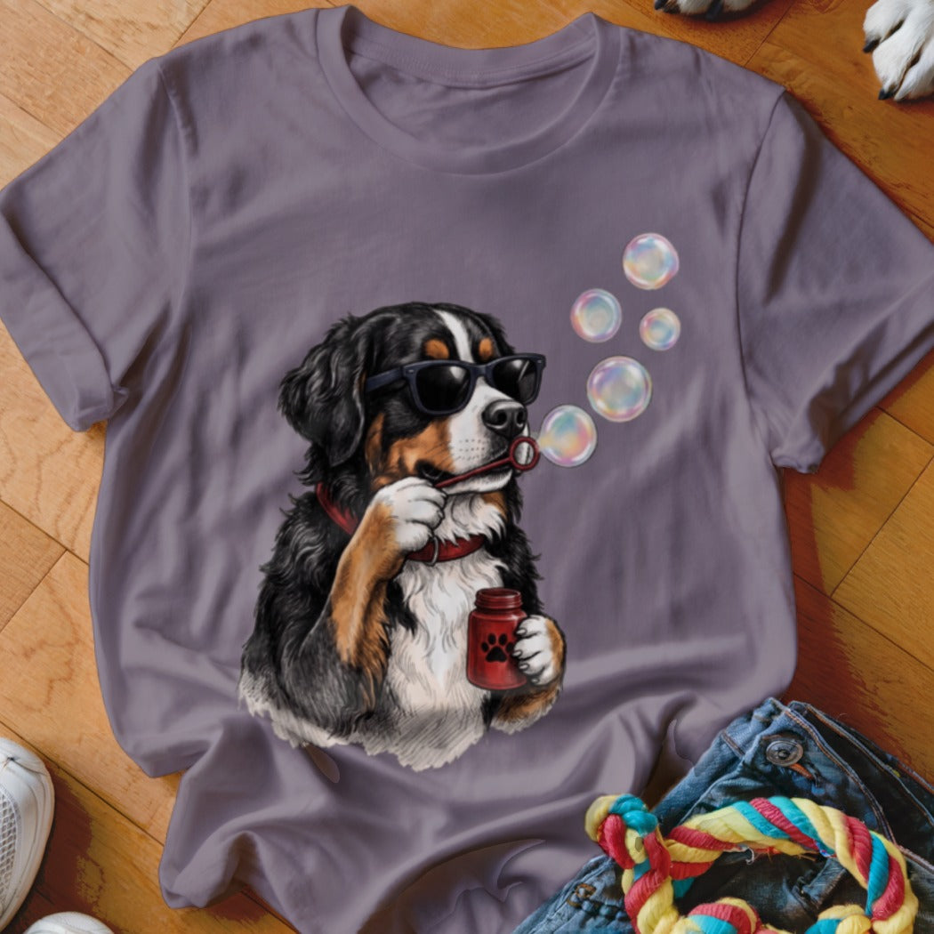 A purple t-shirt features a graphic of a Bernese Mountain Dog wearing sunglasses and blowing bubbles.