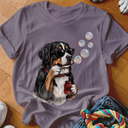 A purple t-shirt features a graphic of a Bernese Mountain Dog wearing sunglasses and blowing bubbles.