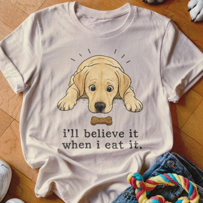 Light-colored t-shirt with a cartoon yellow lab puppy looking at a bone, with text "i'll believe it when i eat it."