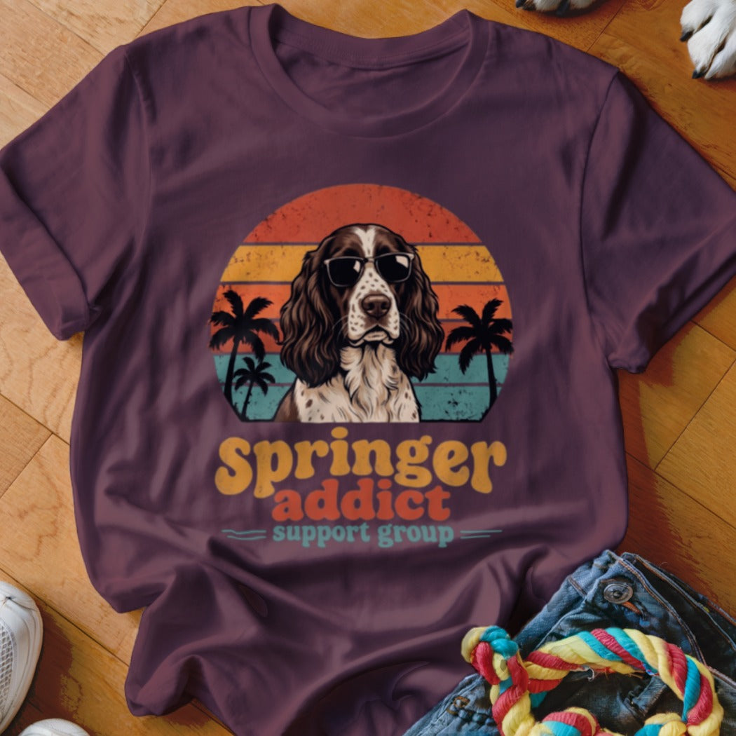 Plum-colored t-shirt featuring a retro sunset graphic of an English Springer Spaniel wearing sunglasses and palm trees.