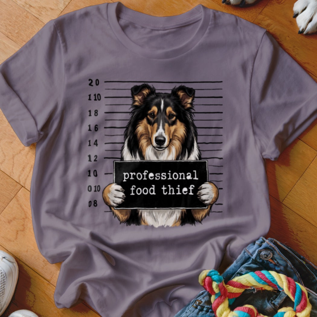 Tricolor dog mugshot with "professional food thief" sign.